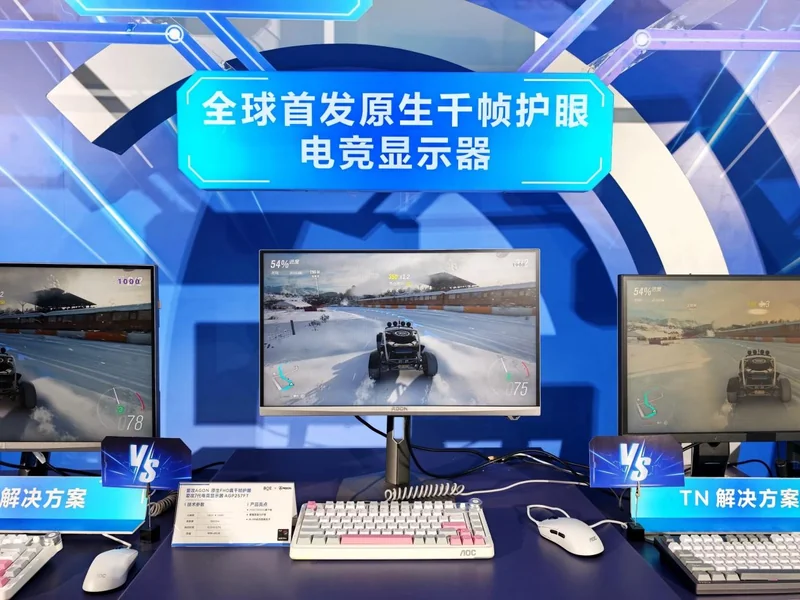 Three AOC monitors display a racing game in a showcase titled '全球首发原生干帧护眼电竞显示器', highlighting different display technologies.