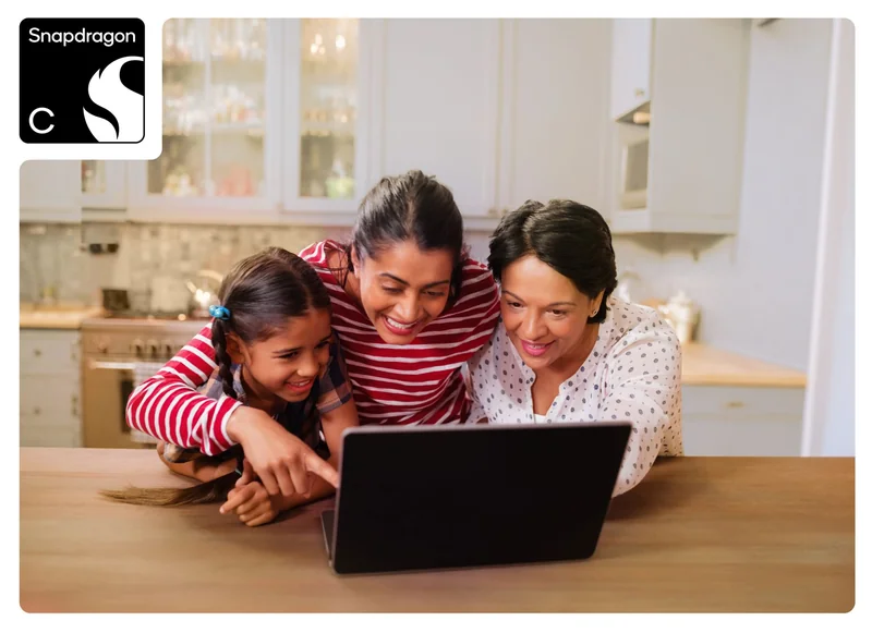 A family of three happily uses a laptop in a kitchen, with a Snapdragon logo in the top-left corner.