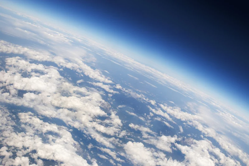 a view of Earth's atmosphere from above, with plenty of scattered clouds.