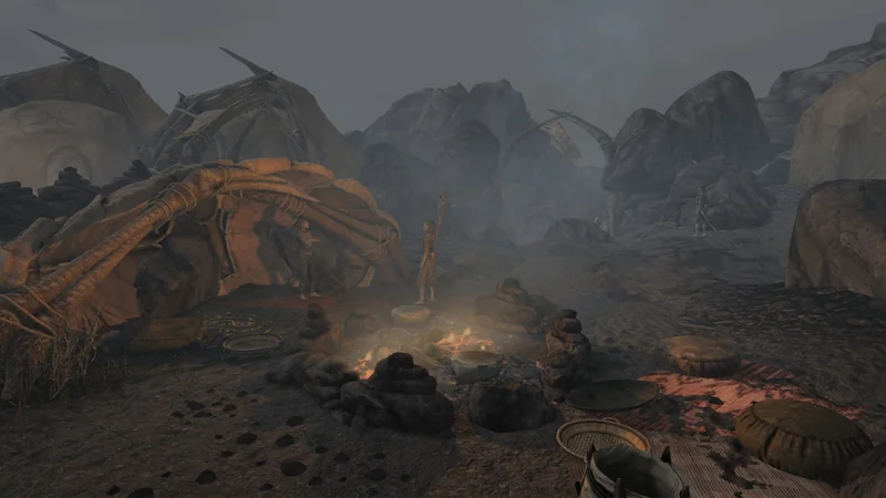 A scene from The Elder Scrolls III: Morrowind showing characters standing near a campsite with a fire and tents set amidst rocky terrain.