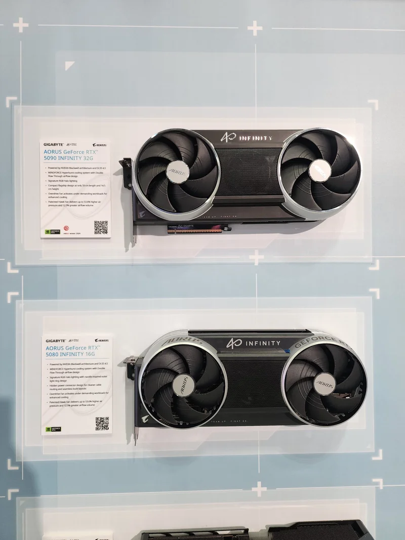Two GIGABYTE AORUS GeForce RTX graphics cards are displayed, labeled as 'AORUS GeForce RTX 5090 INFINITY 32G' and 'AORUS GeForce RTX 5080 INFINITY 16G,' each with dual fans and a visible information card.