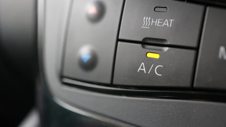 A car's interior showing the AC button turned on.
