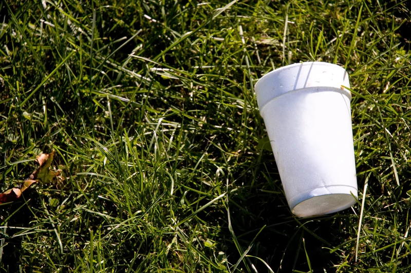 An empty styrofoam coffee cup lying on the ground.