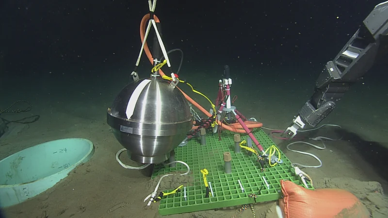 Image of scientific equipment being installed on the ocean floor.