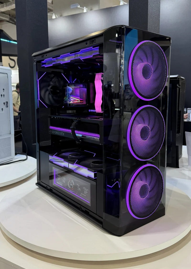 A high-performance gaming PC featuring a GeForce RTX graphics card and three large front fans with purple LED lighting.