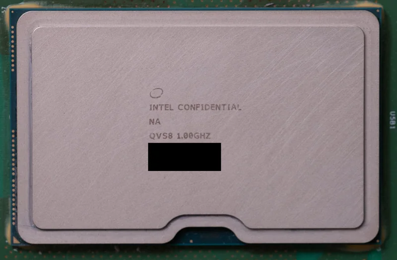 A close-up of an Intel processor labeled 'INTEL CONFIDENTIAL,' 'QVS8 1.00GHZ,' with parts of the text blacked out.