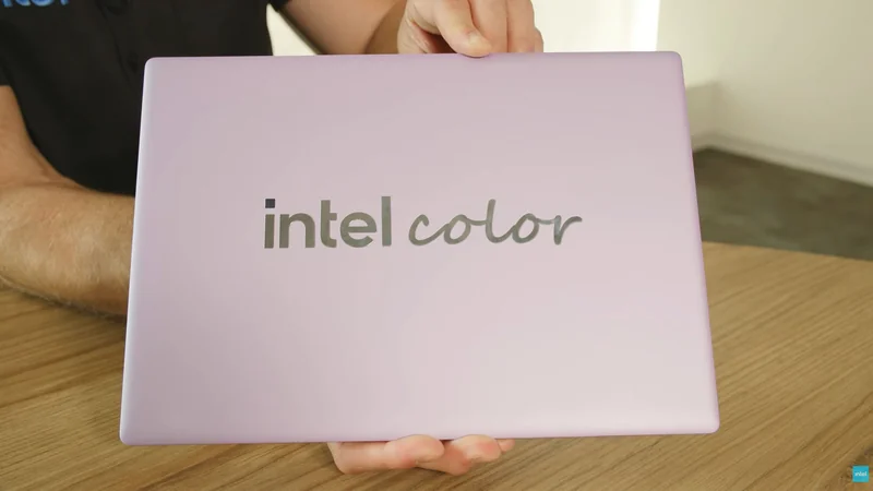 A person holds a lavender-colored laptop with the text 'intel color' on the lid.