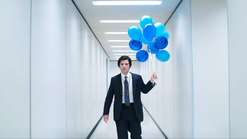 Man in suit walking down a narrow, brightly-lit hallway, holding a bunch of blue balloons.