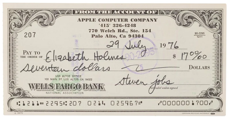Vintage Wells Fargo Bank check from Apple Computer Company, dated July 29, 1976, made out to Elizabeth Holmes for seventeen dollars, featuring ornate border design and signed by Steven Jobs