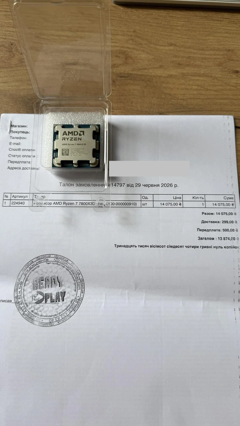 An AMD Ryzen 7 7800X3D processor in a clear case is placed on a purchase document labeled with the same model number.