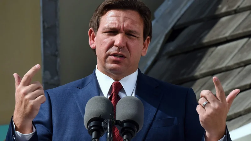 Florida Gov. Ron DeSantis speaks at a press conference while gesturing with his hands.
