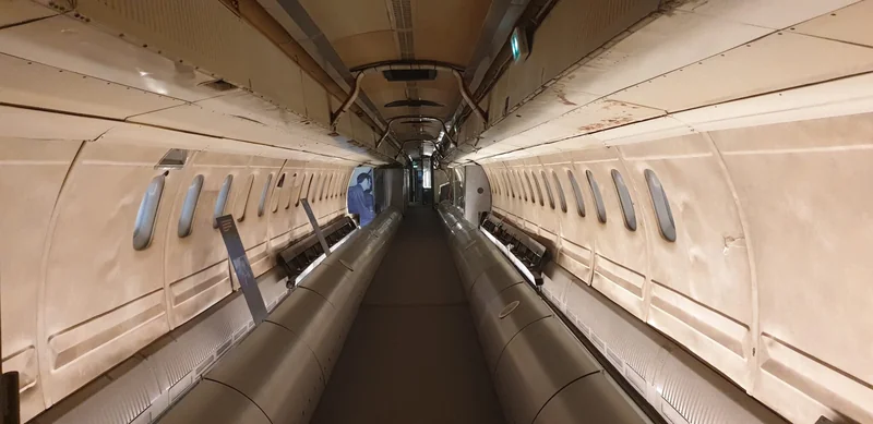 Image of the inside of a narrow aircraft, with no seating visible.