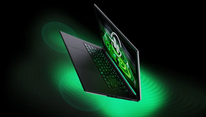A sleek, unbranded gaming laptop with illuminated green keyboard and green graphics on the screen is shown against a black background with green light effects.