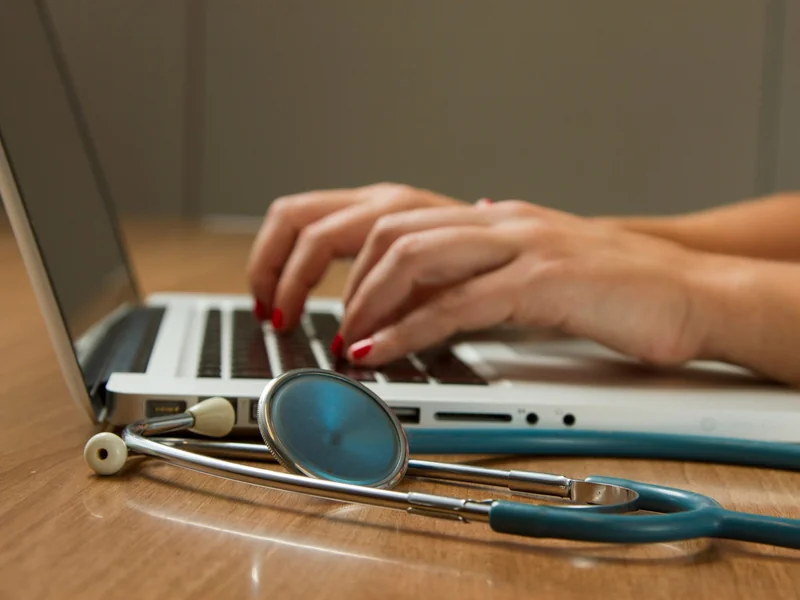 Doctor on a laptop as Google’s research medical AI system, AMIE (Video), conducted synchronous video consultations with professional patient actors and received clinical evaluator ratings on par with primary care physicians across several core measures.