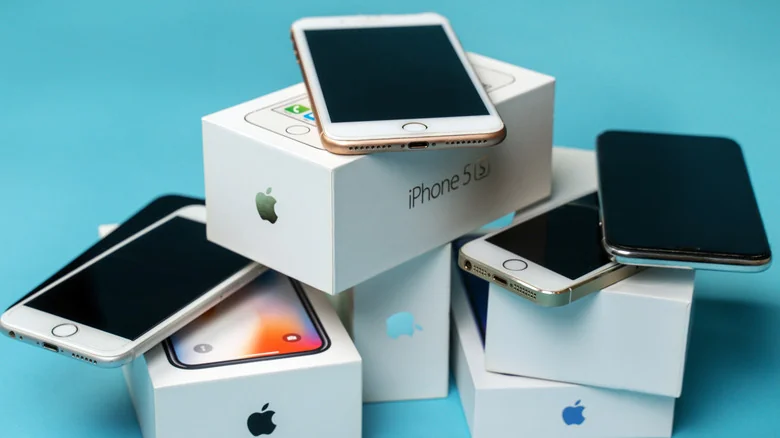 Several old iPhones along with their boxes