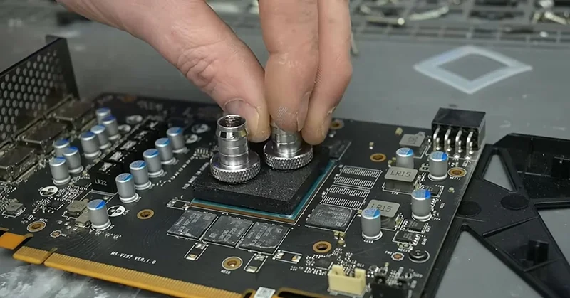A person is attaching cooling fittings to a circuit board labeled 'MS-V327 VCR1.0'.