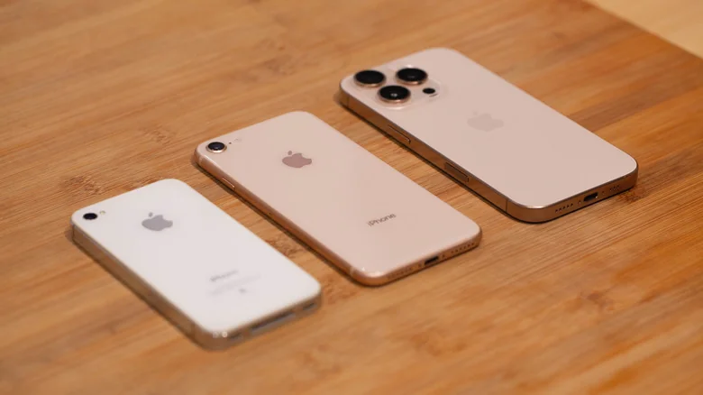 An iPhone 4S, 8, and 16 Pro face-down on a table