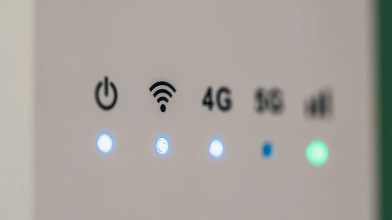 Close-up of a wireless router showing illuminated power, Wi-Fi, 4G and signal-strength indicators.