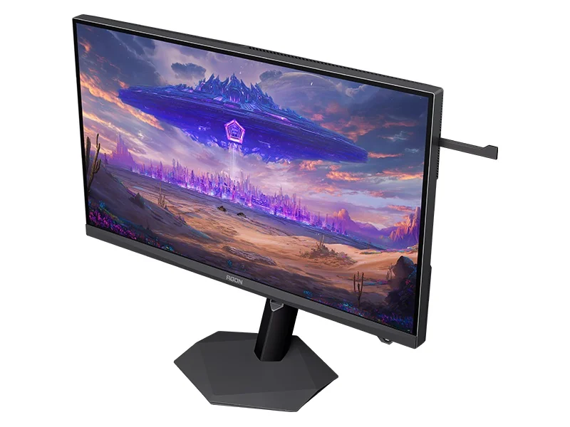 An AOC AGON gaming monitor displaying a vibrant sci-fi landscape with a large floating structure above a purple-lit city.