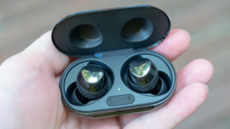 Close-up of wireless earbuds in hand.