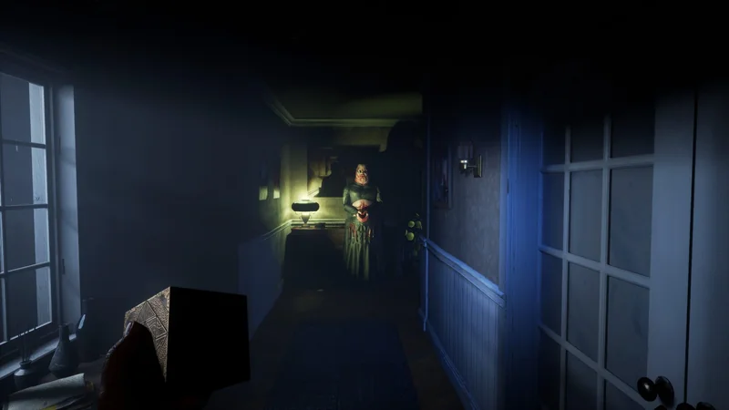A character in the horror game Lies of P stands in a dimly lit corridor holding a lamp, with a hand holding a detailed box in the foreground.