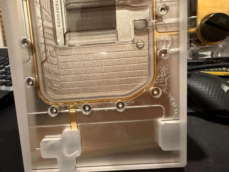 A close-up of a Bykski water block with visible internal coolant channels and mounting screws.
