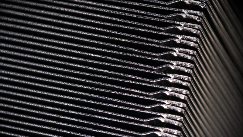 Close-up of a metallic heatsink with parallel cooling fins.