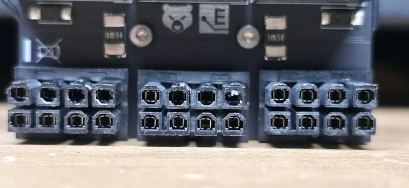 A close-up of a graphics card's power connector ports, showing signs of wear and damage.