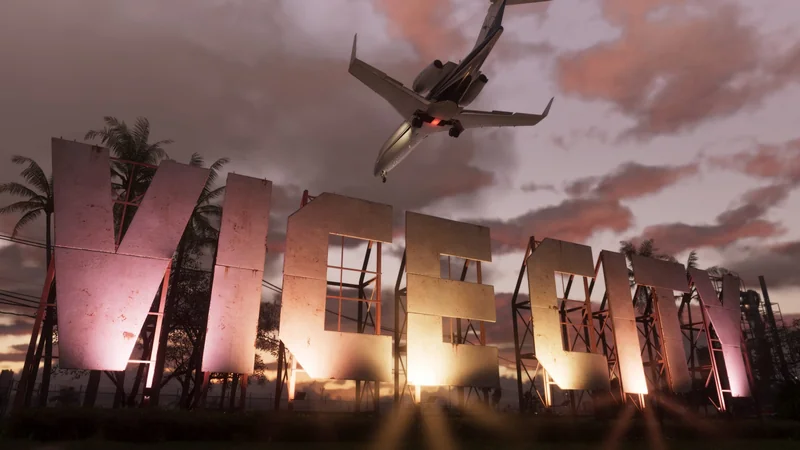 An airplane flies over a large, illuminated VICE CITY sign against a backdrop of palm trees and a sunset sky.