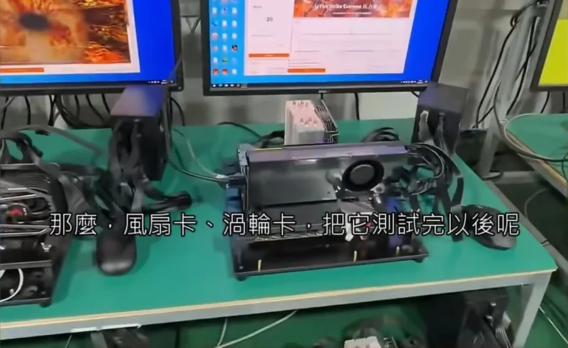 A setup showing a test bench with a graphics card under stress testing, featuring two monitors, one displaying a 'FurMark' stress test and the other showing a 'FireStrike Extreme' score.