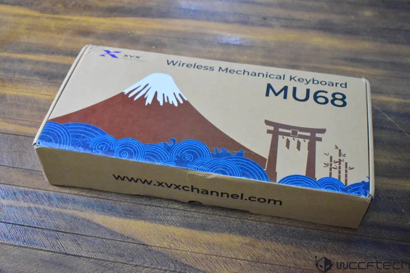 A box of the XVX Wireless Mechanical Keyboard MU68 featuring mountain and wave artwork, with the website www.xvxchannel.com printed at the bottom.