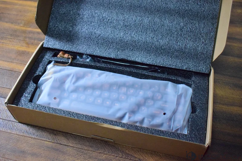 A keyboard in protective packaging inside a cardboard box.